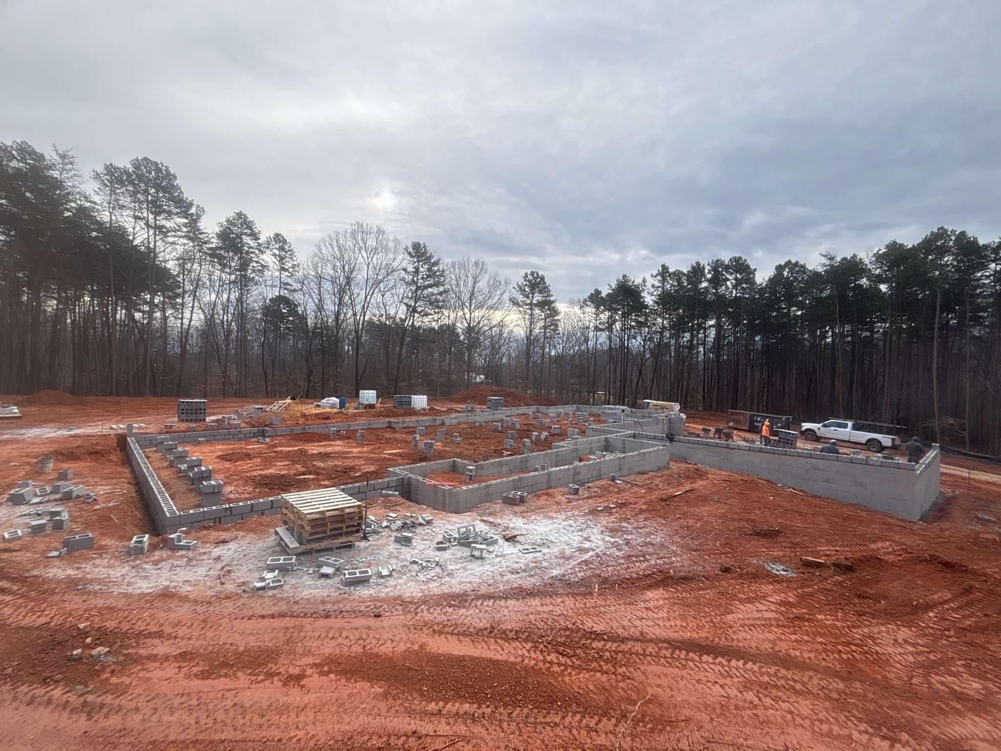 Progress shots of a new custom home build, documenting the transition from the masonry foundation to the fully framed and dried-in structure.